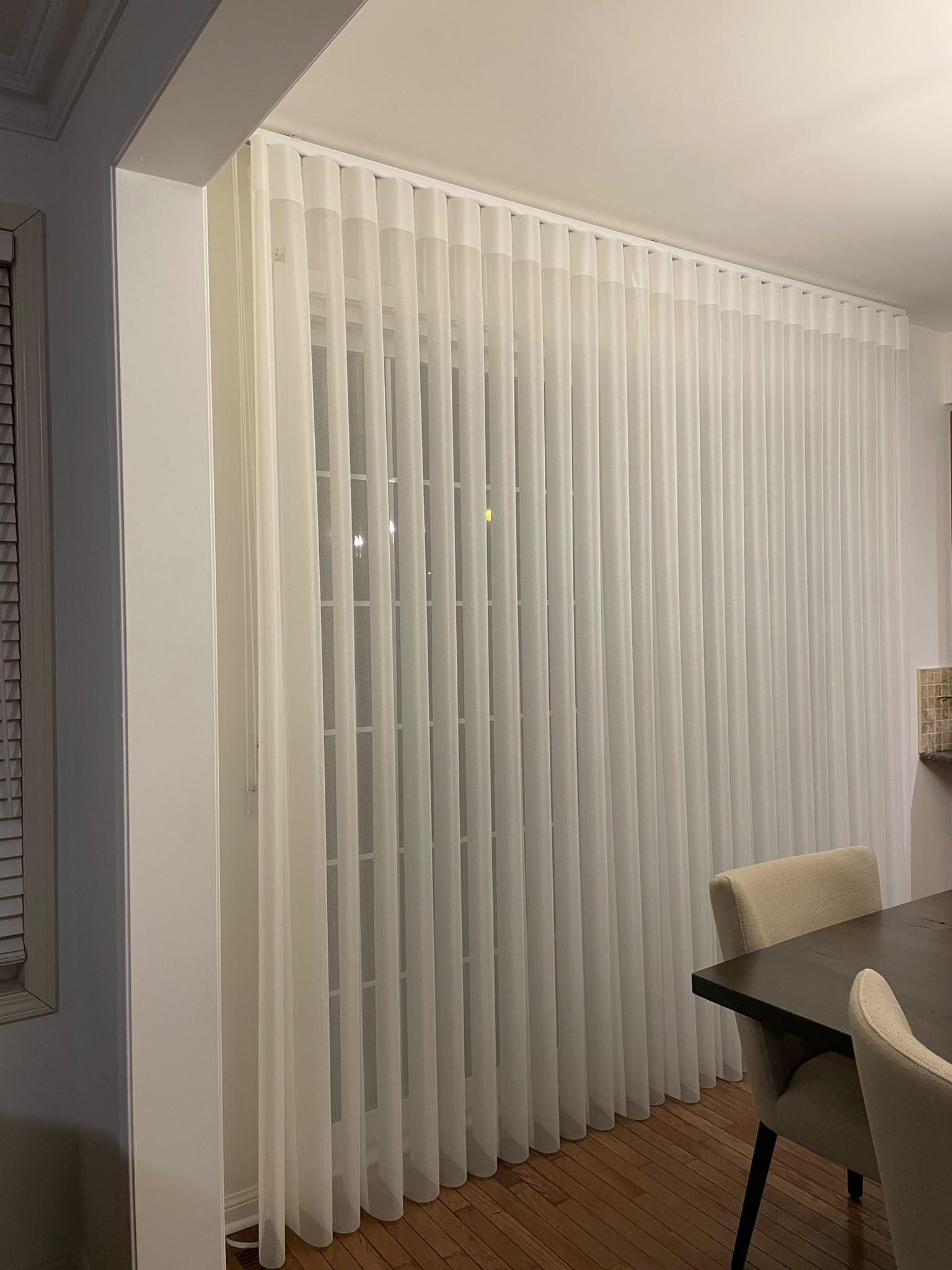 Craftsman measuring roller shade fabric in workshop